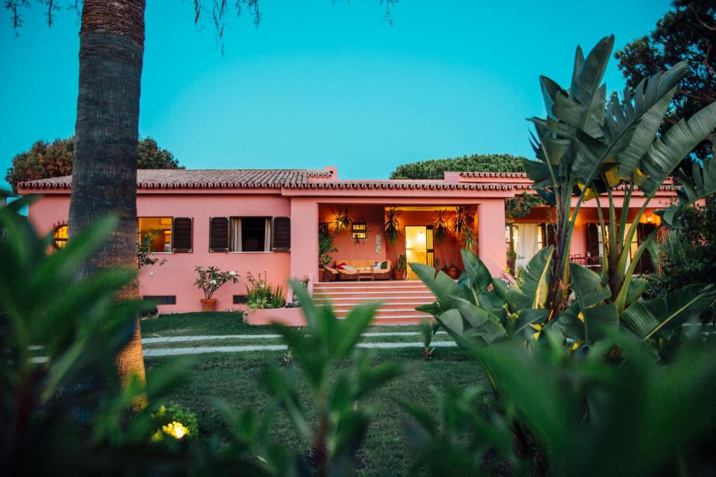 a pink house with a palm tree in front of it at Charismatic Villa Pitanga Private pool and garden in Quarteira