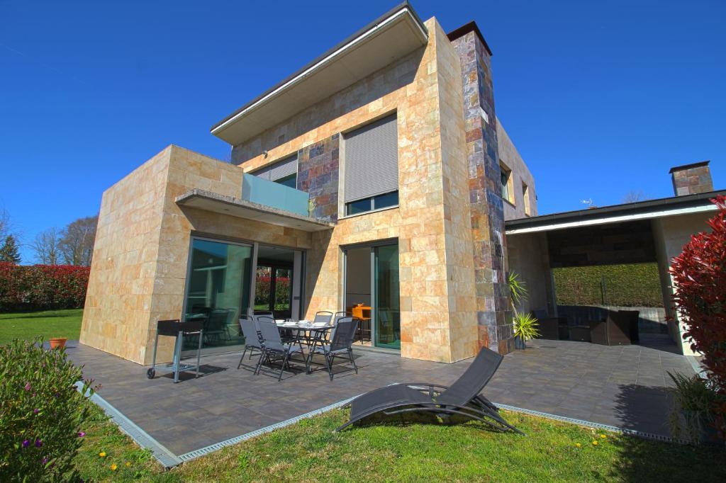 uma casa com um pátio com uma mesa e cadeiras em El Chalet de Lola em Santillana del Mar