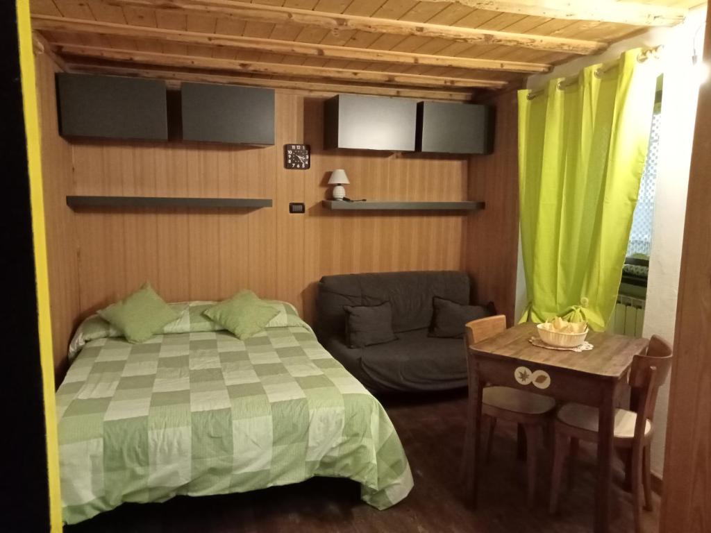 a bedroom with a bed and a couch and a table at Domy CENTRAL STUDIO in Aosta