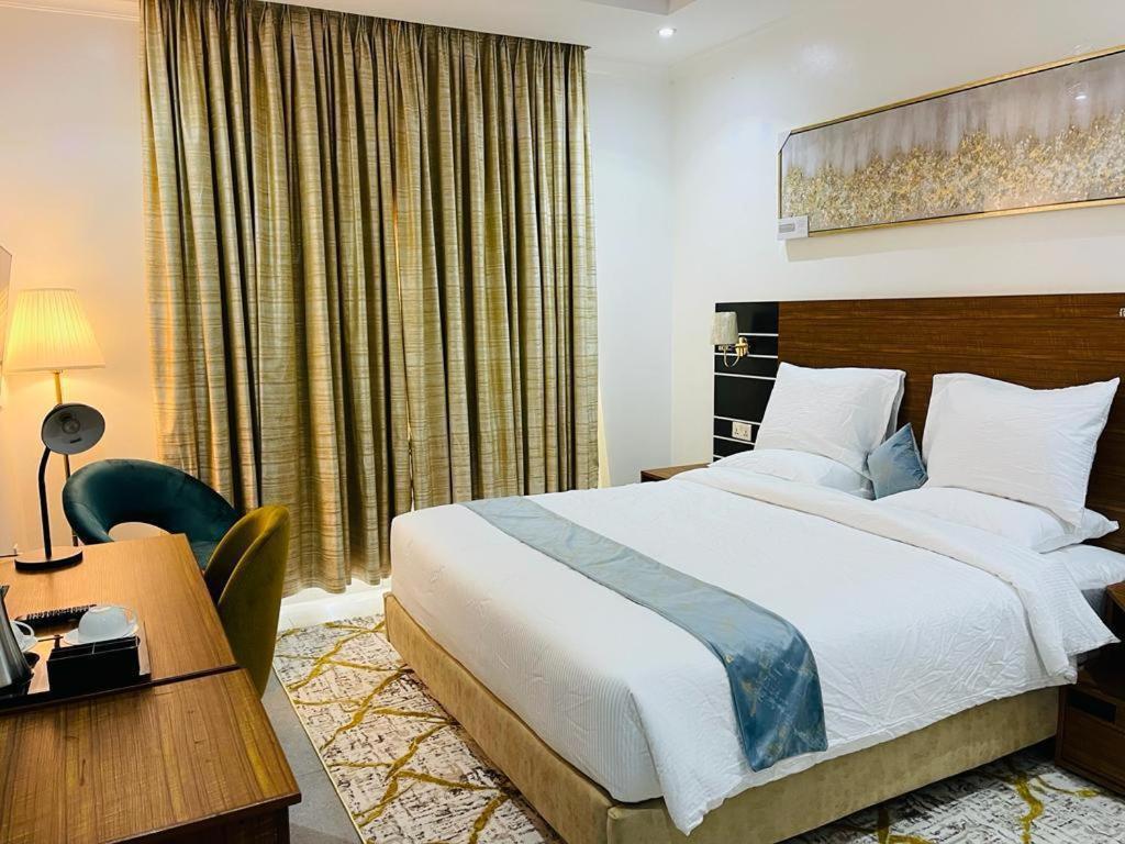 um quarto de hotel com uma cama e uma secretária em Randa Boutique Hotel em Kigali