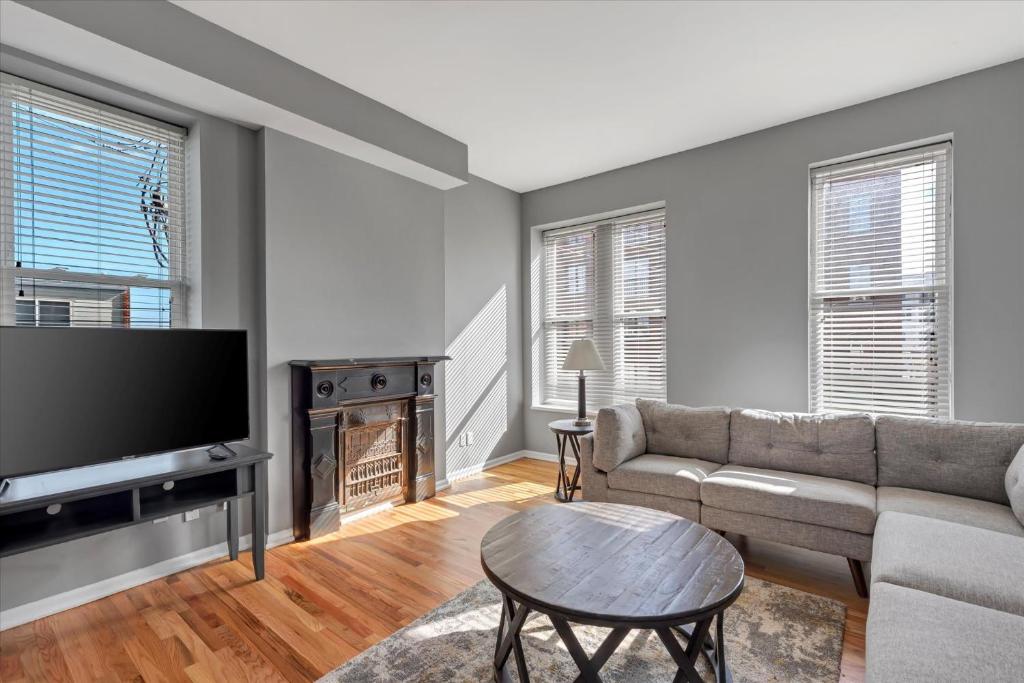 a living room with a couch and a tv at 713a - Settle in Historic Soulard in Soulard