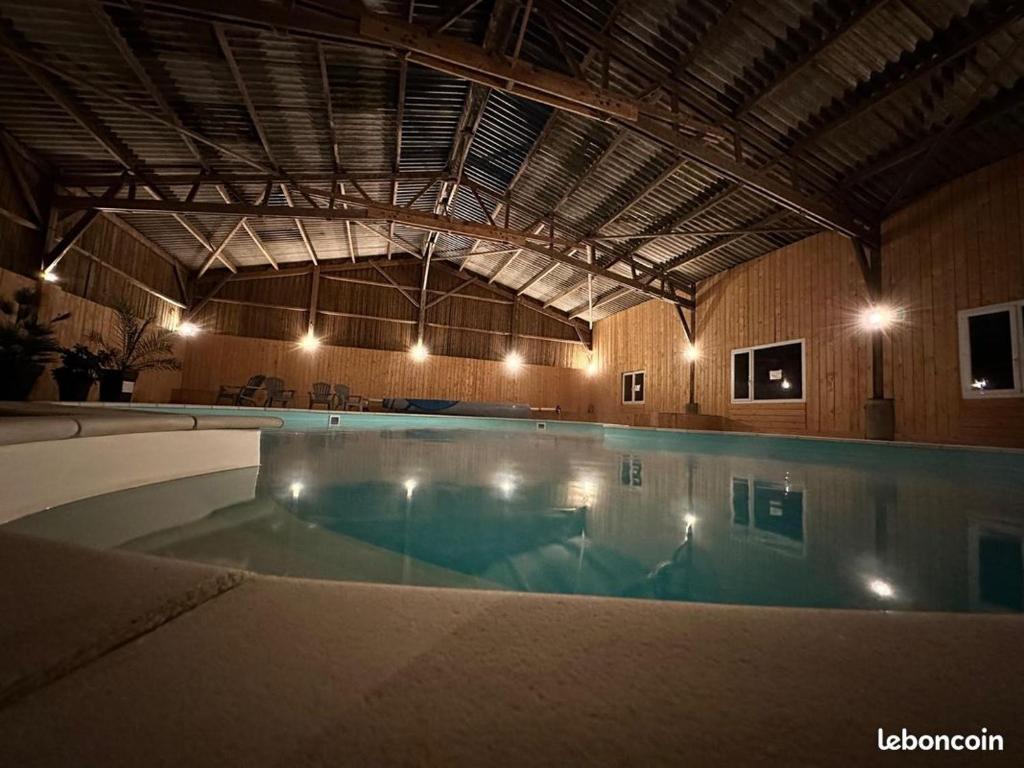 - une grande piscine dans un bâtiment doté d'un plafond dans l'établissement Domaine Des Hêtres, à Longraye