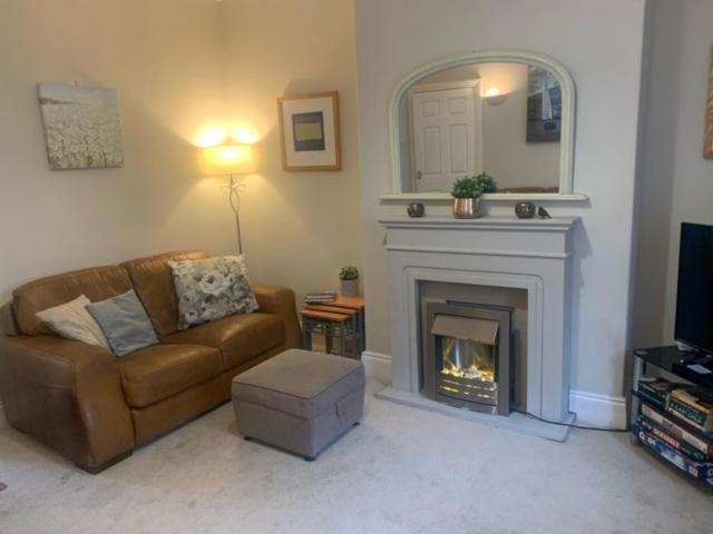 a living room with a couch and a fireplace at Sea to City House in Whitley Bay