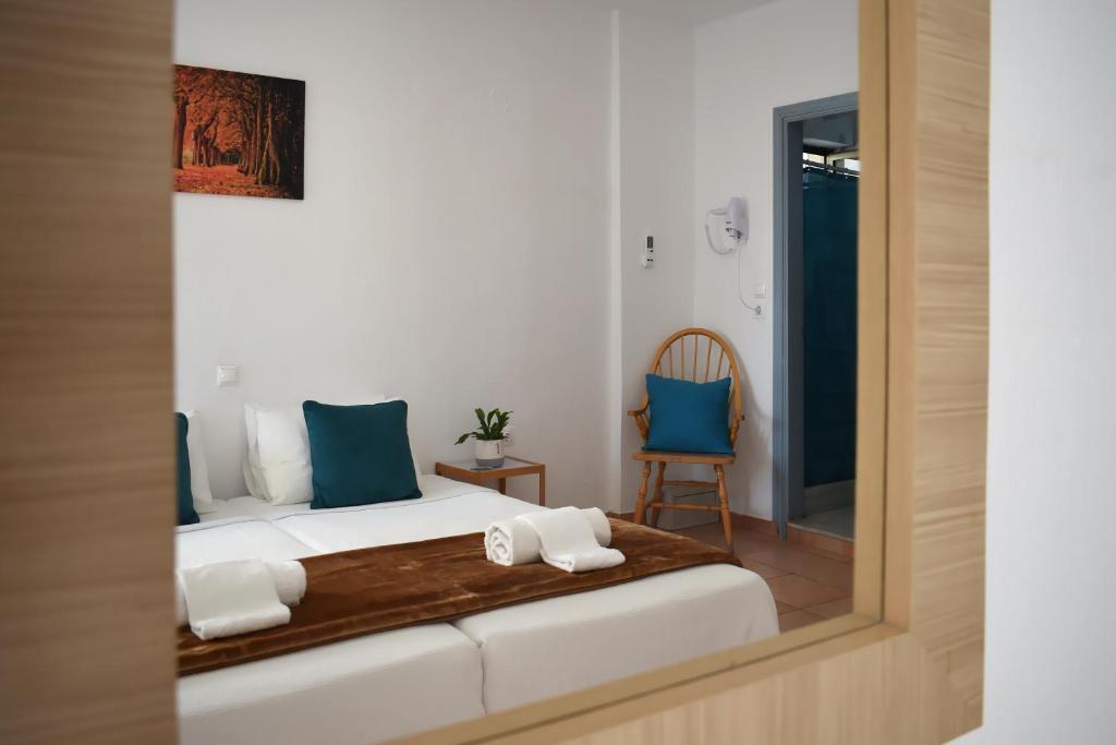 um quarto com uma cama com almofadas azuis e um espelho em Marnin Apartments in Ilha de Rhodes