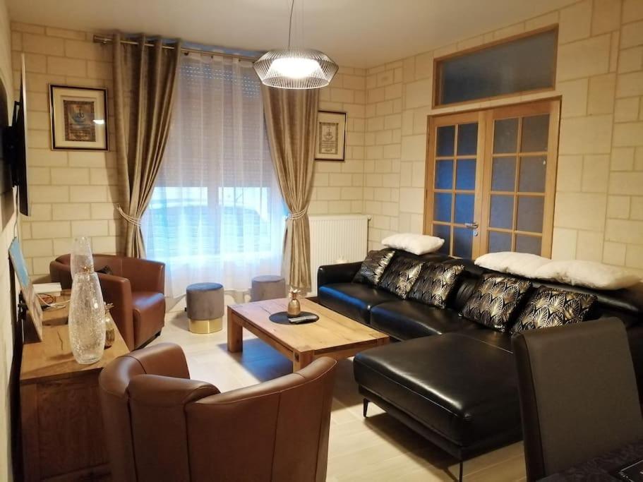 - un salon avec un canapé et des fauteuils en cuir noir dans l'établissement La dolce vita (150m2) : maison 4 chambres, à Anzin