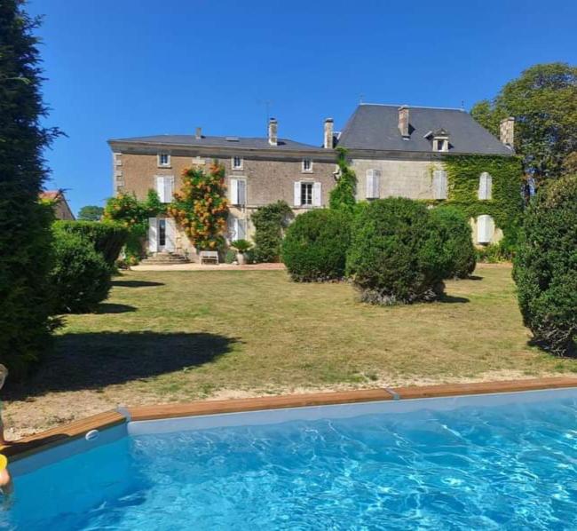 une grande maison avec une piscine devant dans l'établissement Gîte Manoir Saint Thomas, à Oulmes