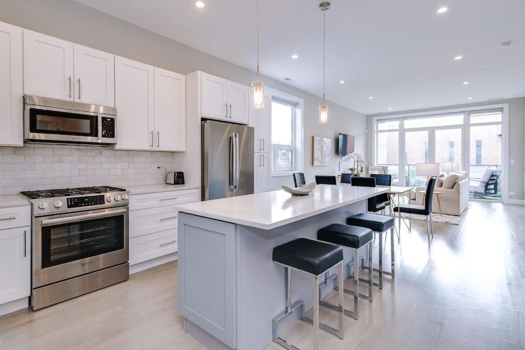 a kitchen with white cabinets and a kitchen island with stools at Stunning Condo #2 - Downtown River North in Chicago