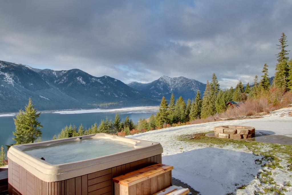 a hot tub on a hill with a view of the mountains at Dazzling Cle Elum Home with Game Room and Fire Pit! in Ronald
