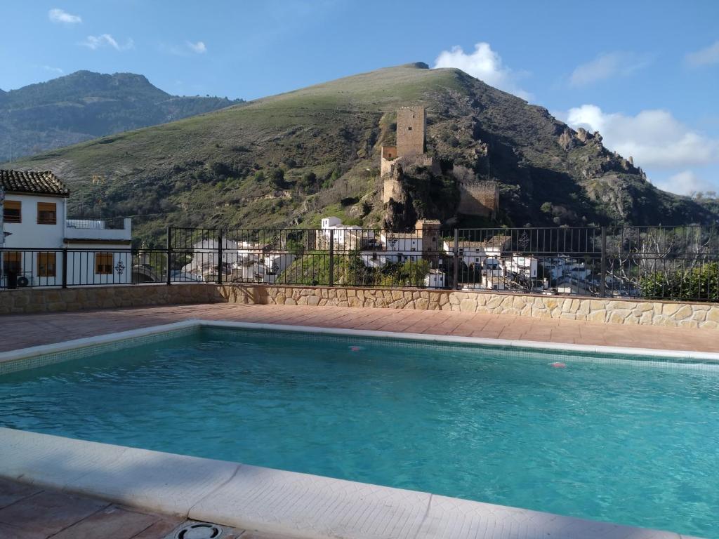 una piscina con una montaña en el fondo en Casa Tio Paco, en Cazorla