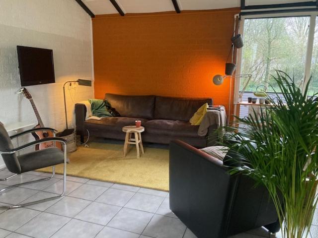 een woonkamer met een bank en een tafel bij Zuid Limburg Huisje Josefien in Simpelveld