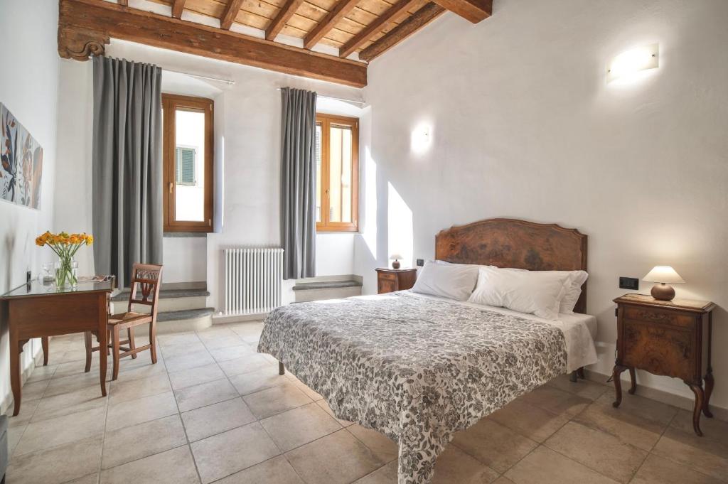 San Niccolò Luxury Apartment في فلورنسا: غرفة نوم بسرير وطاولة ومكتب