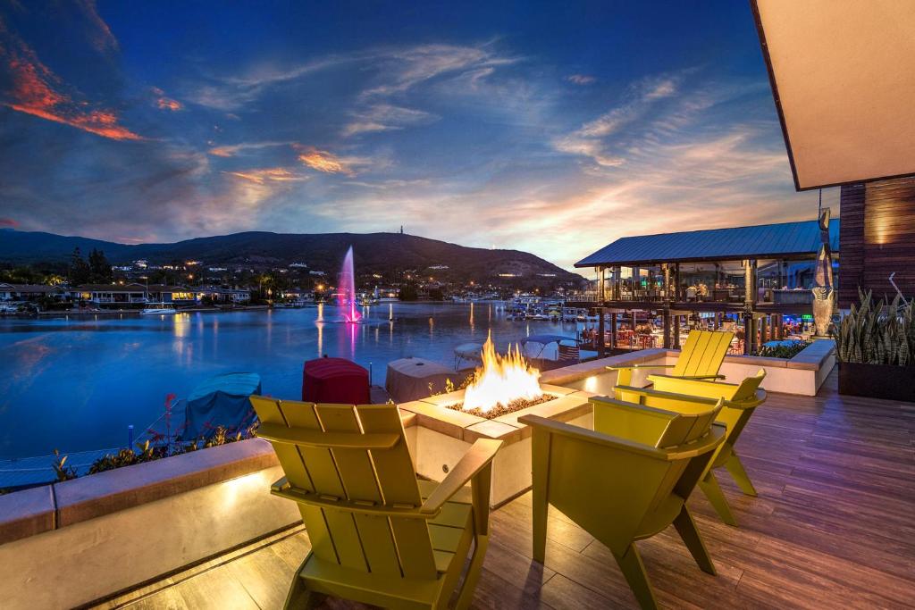 een patio met een open haard en stoelen en uitzicht op het water bij Lakehouse Resort in San Marcos