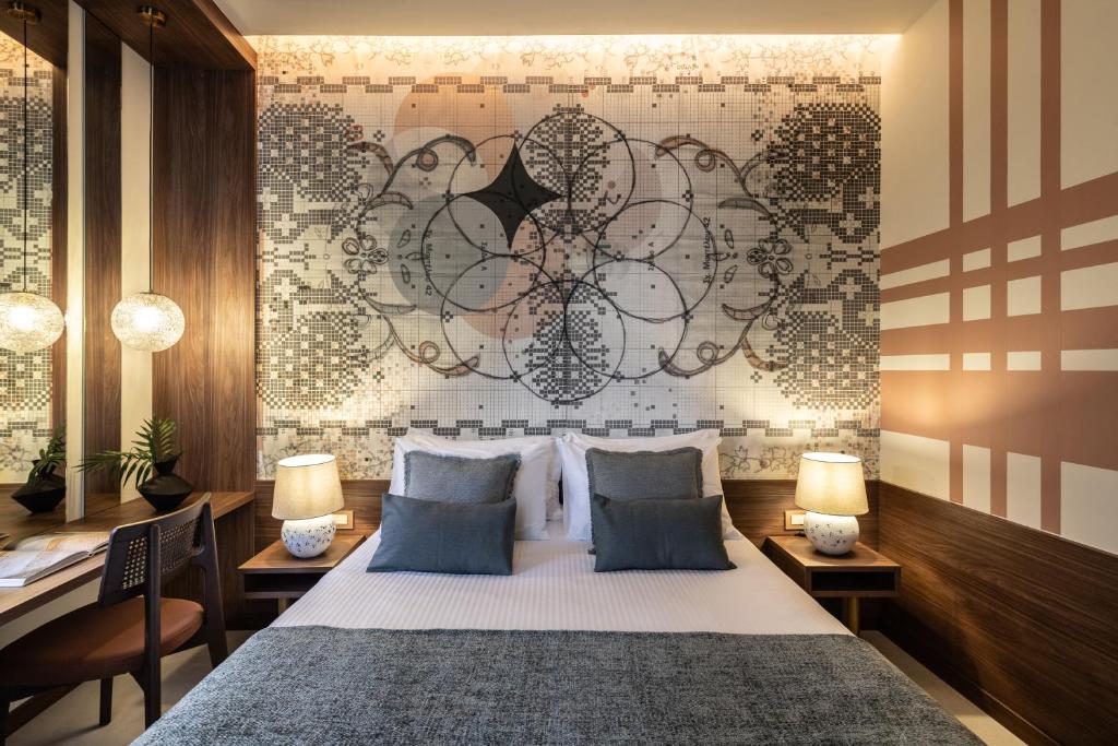 a bedroom with a bed with two lamps and a wall at MEDLEY in Athens