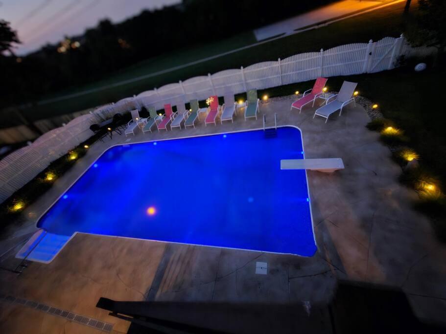 an overhead view of a blue swimming pool with chairs at Spacious Pool House with tons of amenities! in Omaha