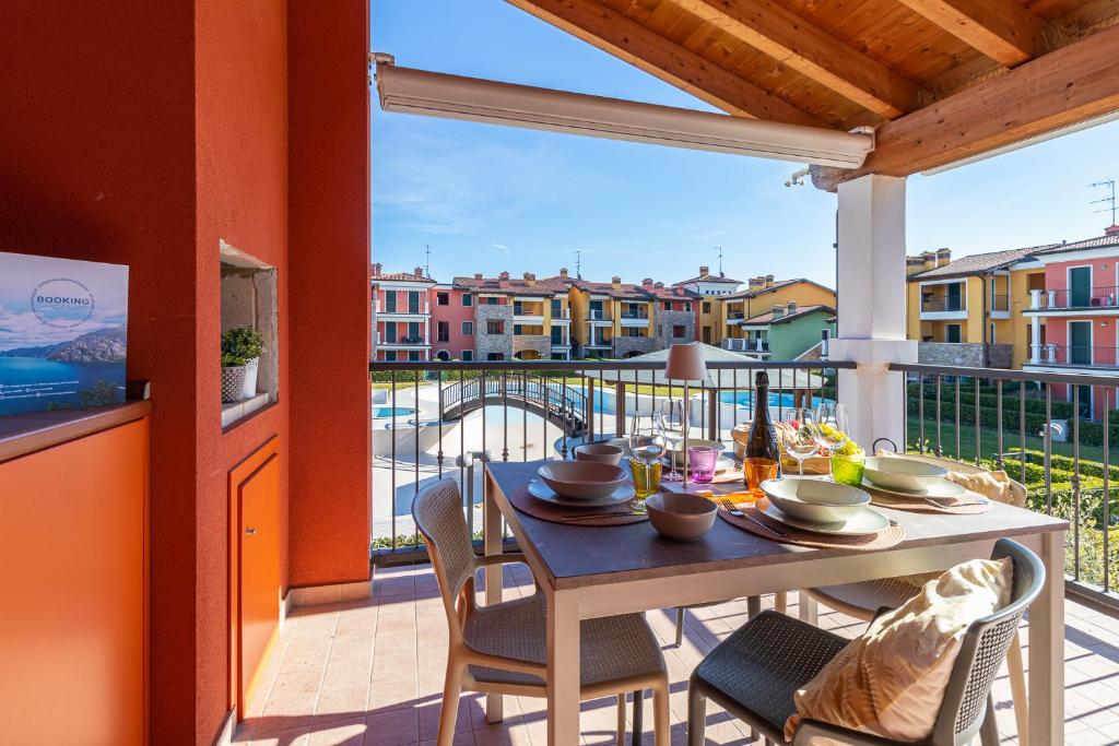 een tafel en stoelen op een balkon met uitzicht bij Appartamento Le Vele - BGL in Sirmione