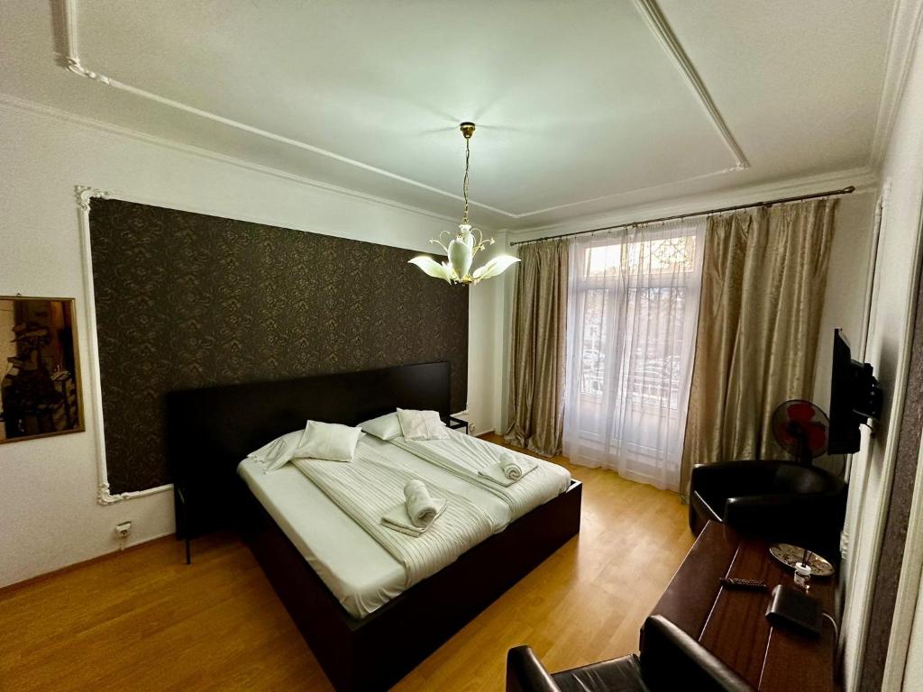 una camera con letto e lampadario a braccio di Garsoniera ultracentral a Bacău