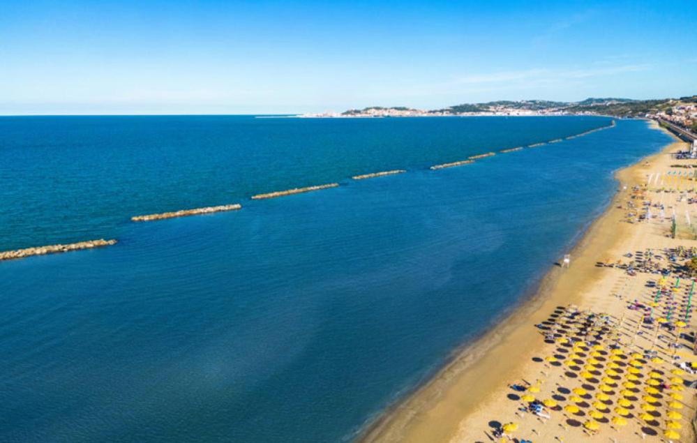 una vista aerea su una spiaggia con sedie e ombrelloni di Residence Carmen a Falconara Marittima