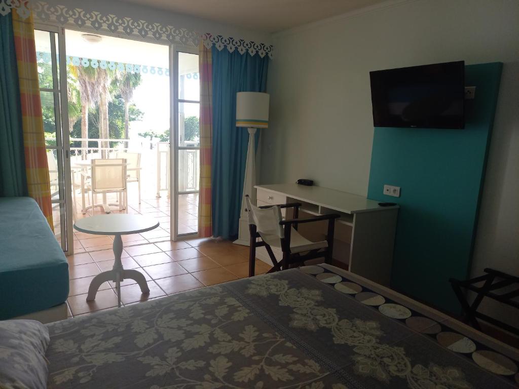 a bedroom with a bed and a desk and a table at Appartements VUE MER et PARC in Sainte-Luce