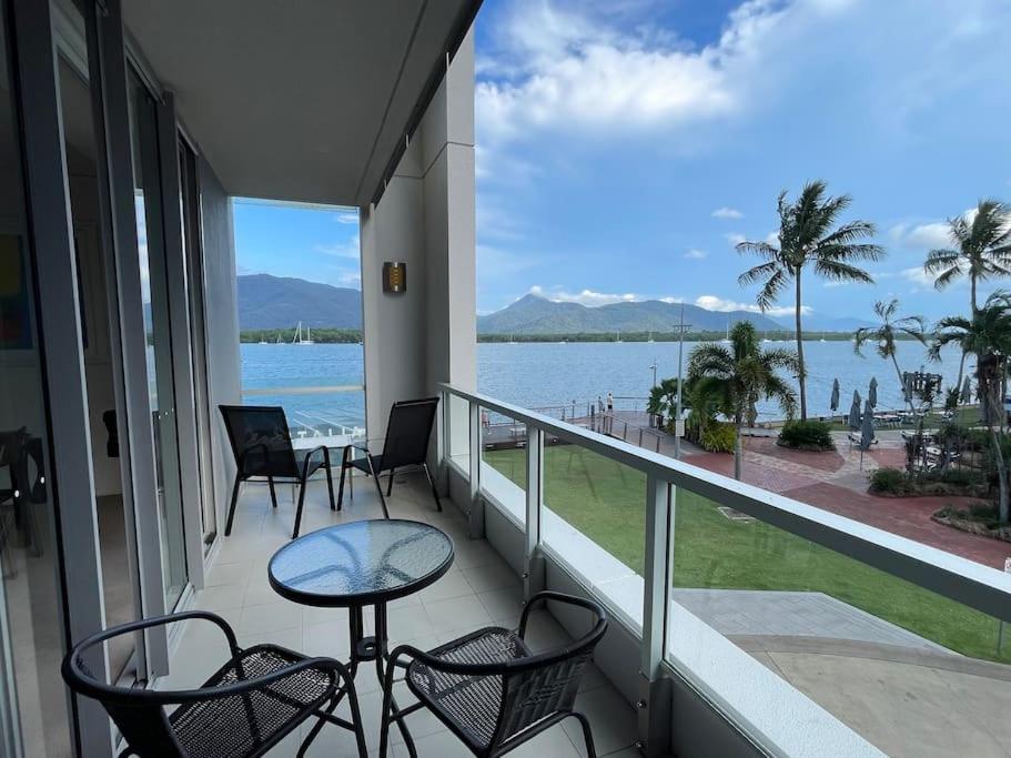 uma varanda com cadeiras e uma mesa e vista para a água em Stunning Water View Apartment - Pool, Gym, Sauna. em Cairns