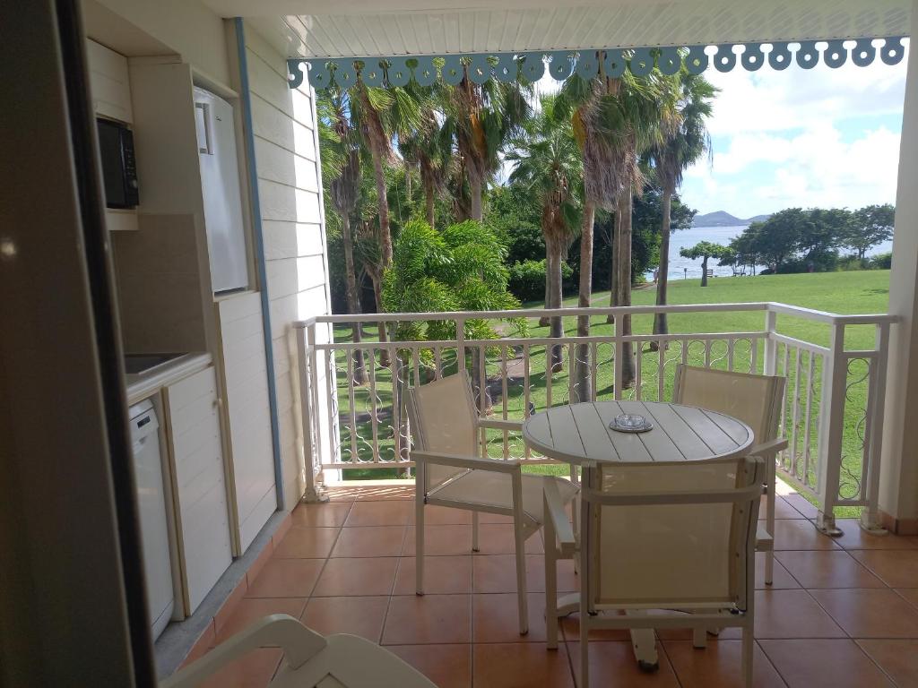 a porch with a table and chairs on a balcony at Appartements VUE MER et PARC in Sainte-Luce