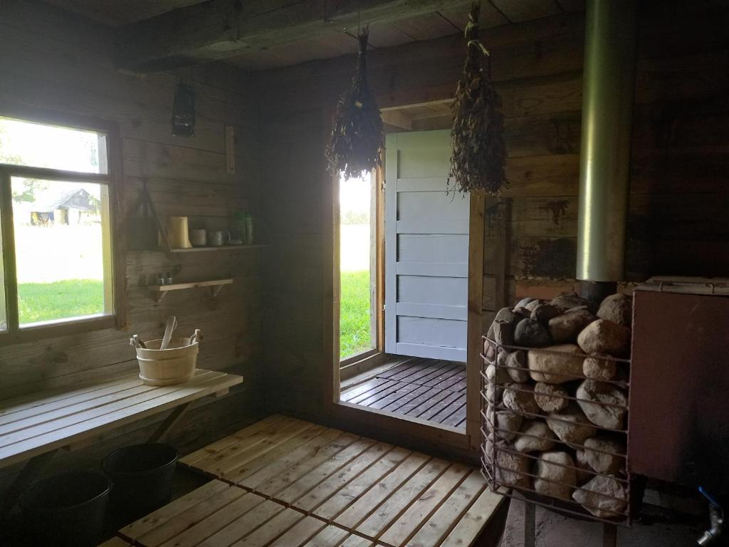 a room with a door and a window and logs at Sīvera krasts in Auleja