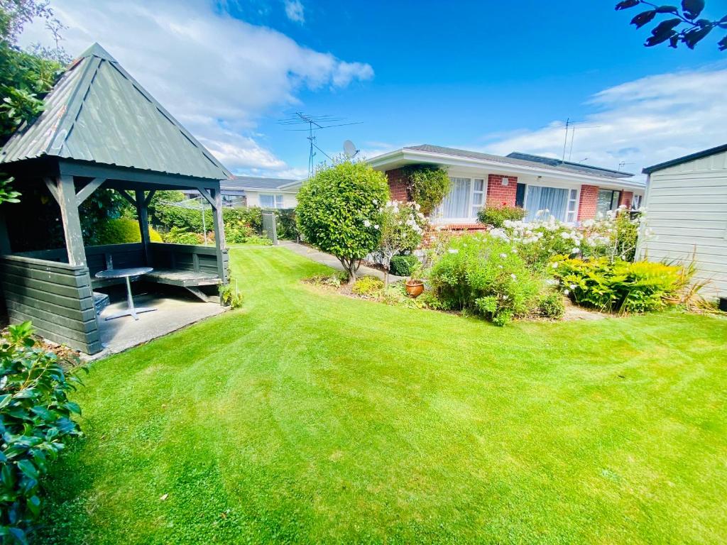 a garden with a gazebo and a lawn at Rosedale Retreat in Invercargill