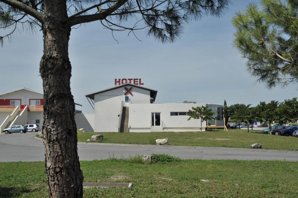 un cartello dell'hotel sulla cima di un edificio bianco di Relais de Barbezieux a Barbezieux-Saint-Hilaire