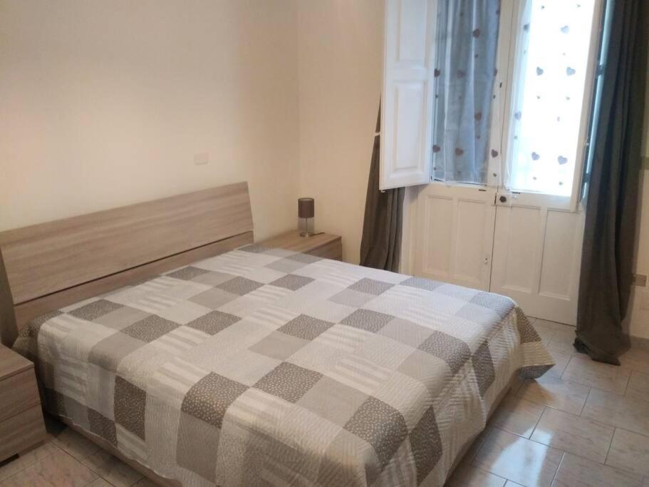 um quarto com uma cama com um cobertor xadrez em La casina di Laura em Maglie