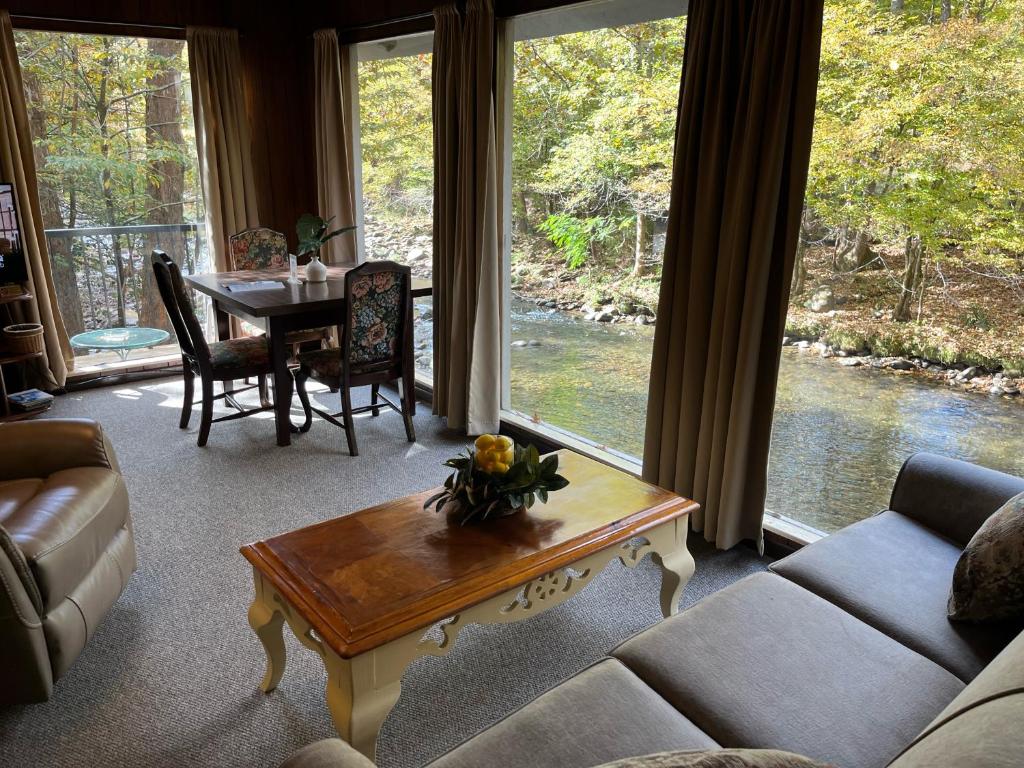 a living room with a table and a large window at River Rhapsody in Sevierville