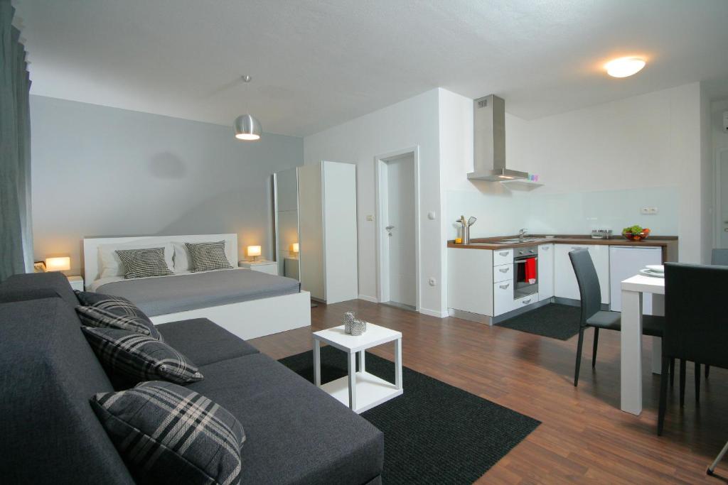 a living room with a couch and a bed and a table at Charm Apartments And Rooms in Trogir