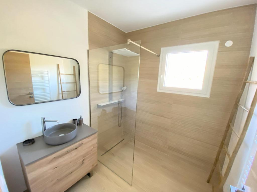 a bathroom with a sink and a shower with a mirror at Villa d'exception piscine privée et vue mer in Saint-Cyr-sur-Mer