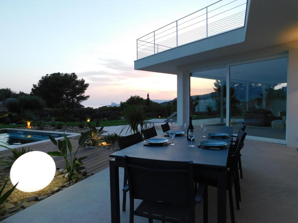 a dining table on the patio of a house at Villa d'exception piscine privée et vue mer in Saint-Cyr-sur-Mer
