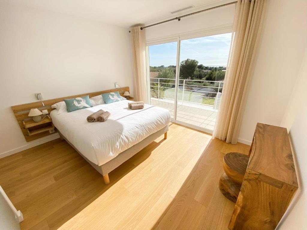 a bedroom with a bed and a large window at Villa d'exception piscine privée et vue mer in Saint-Cyr-sur-Mer
