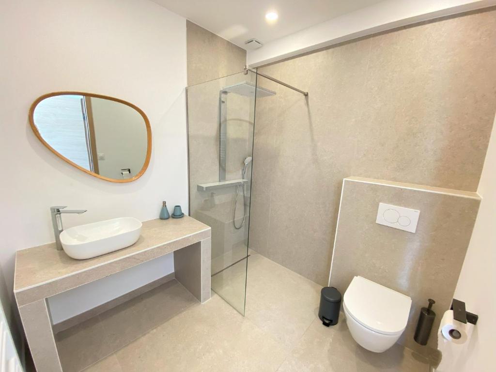 a bathroom with a sink and a toilet and a mirror at Villa d'exception piscine privée et vue mer in Saint-Cyr-sur-Mer