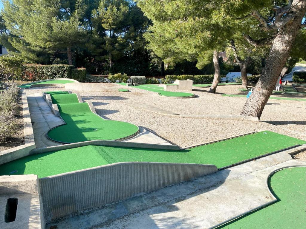 a green golf course in a park with trees at Villa d'exception piscine privée et vue mer in Saint-Cyr-sur-Mer
