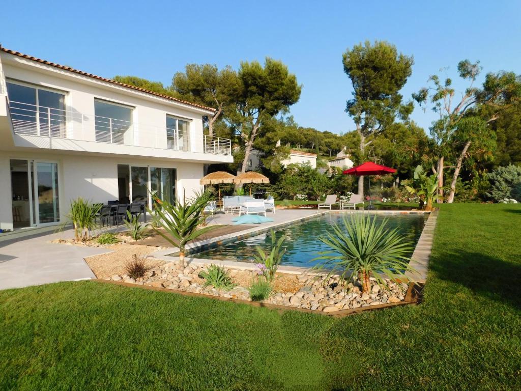 a house with a swimming pool in a yard at Villa d'exception piscine privée et vue mer in Saint-Cyr-sur-Mer