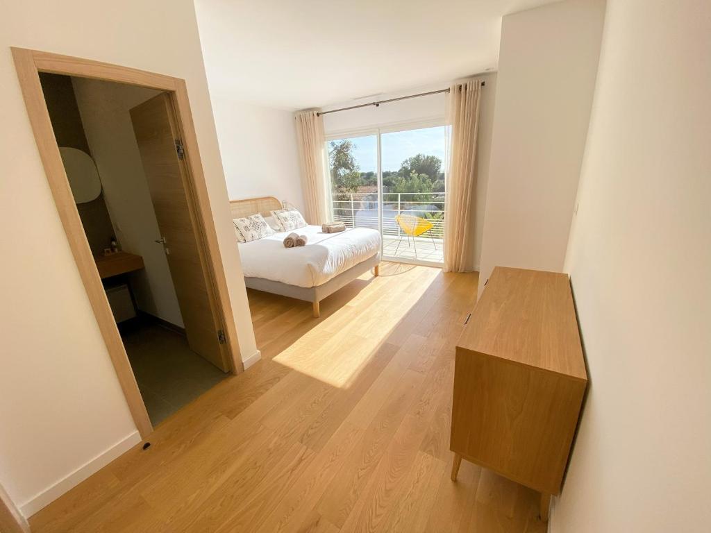 a bedroom with a bed and a table and a window at Villa d'exception piscine privée et vue mer in Saint-Cyr-sur-Mer