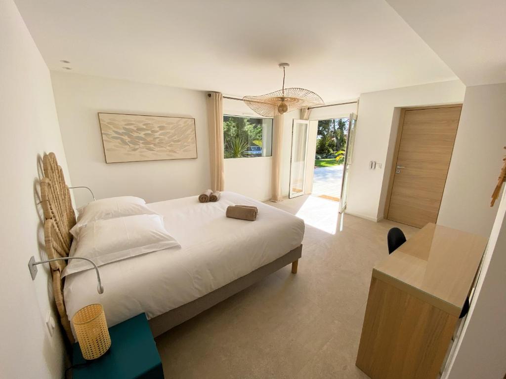 a bedroom with a bed and a large window at Villa d'exception piscine privée et vue mer in Saint-Cyr-sur-Mer