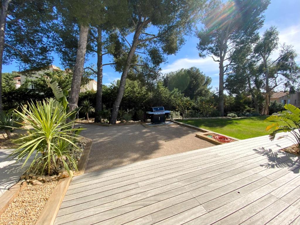 a wooden deck with a bench in a park at Villa d'exception piscine privée et vue mer in Saint-Cyr-sur-Mer
