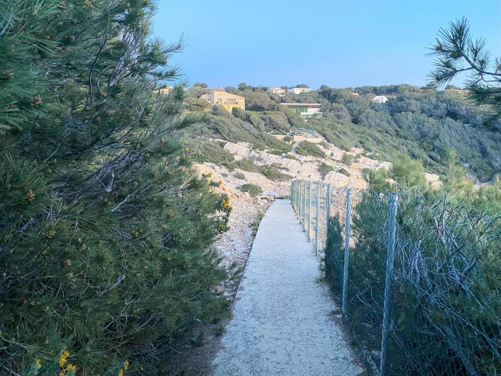 a fence on the side of a hill with trees at Villa d'exception piscine privée et vue mer in Saint-Cyr-sur-Mer