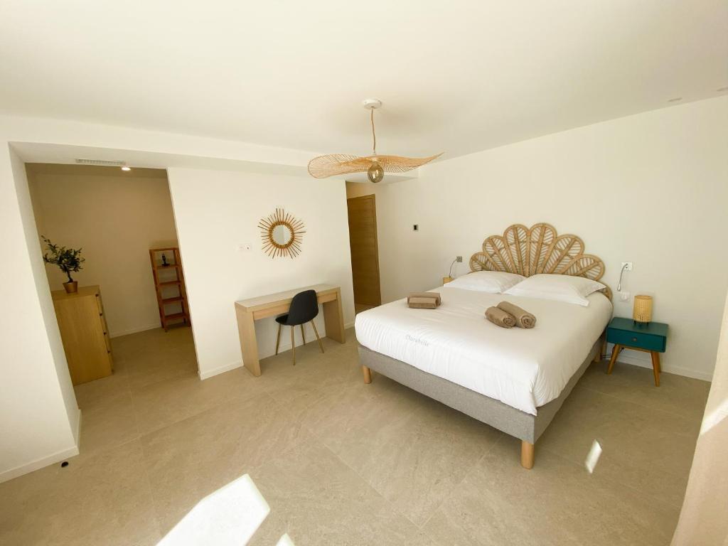 a bedroom with a bed and a desk with a fan at Villa d'exception piscine privée et vue mer in Saint-Cyr-sur-Mer