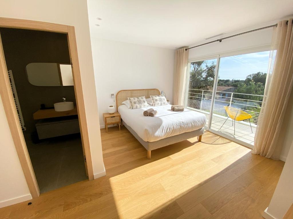 a bedroom with a bed and a balcony at Villa d'exception piscine privée et vue mer in Saint-Cyr-sur-Mer