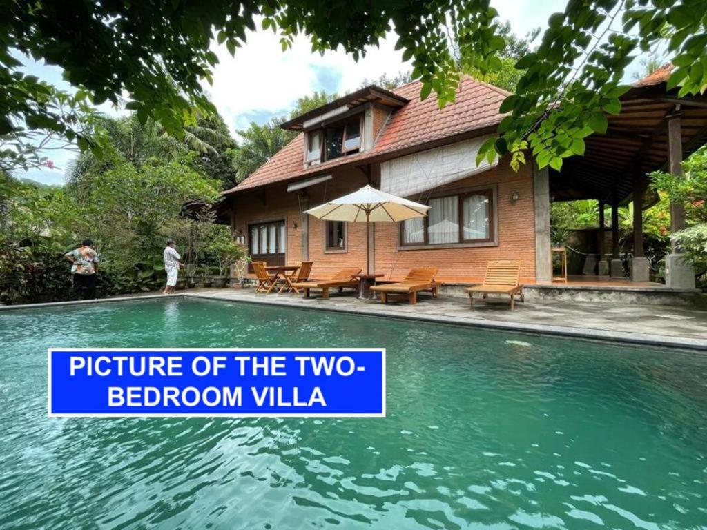 a house with a swimming pool with a sign that reads picture of the two bedroom at Villa Lombok Senggigi Kamila Forest By Villaloka in Mangsit