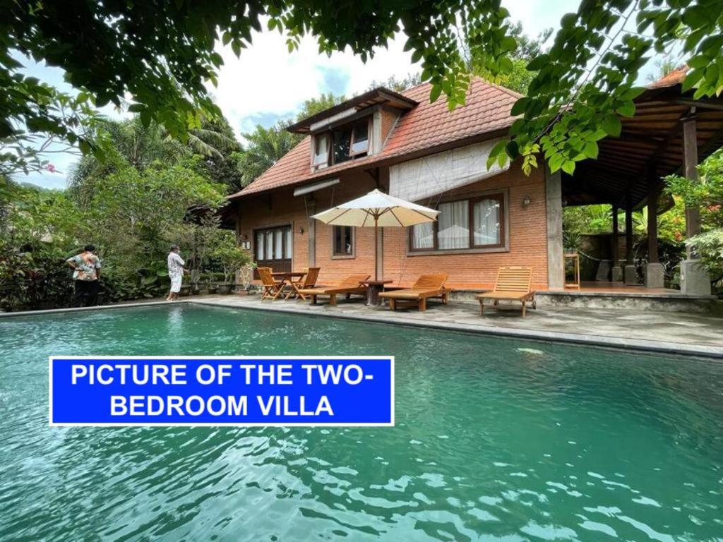 uma casa com uma piscina com uma placa que lê a imagem dos dois quartos em Villa Lombok Senggigi Kamila Forest By Villaloka em Mangsit