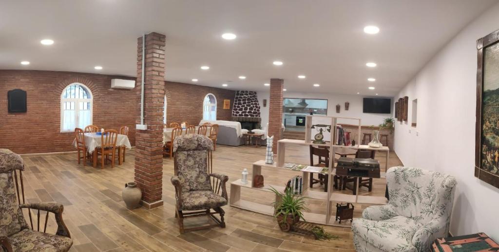 a living room with chairs and a dining room at Alojamiento Turístico La Cantuérgana in San Martín de Montalbán