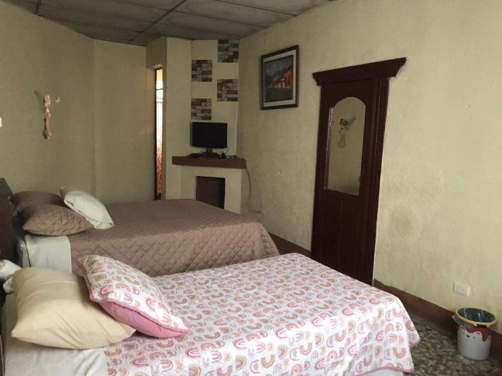 Antigua Sweet Apartment في أنتيغوا غواتيمالا: غرفة نوم بسريرين ومرآة