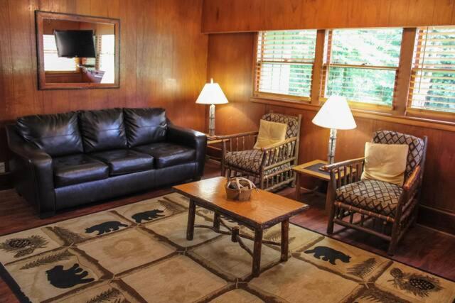 a living room with a black leather couch and chairs at Emma's Cottage #537 in Sevierville
