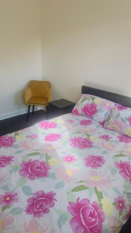 a bedroom with a bed with a floral comforter at Budget Rooms in Fort William
