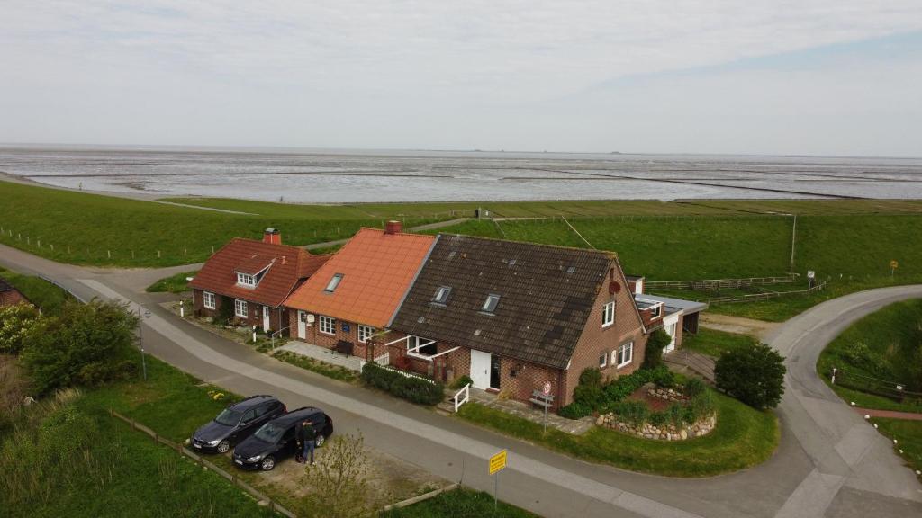 una casa grande con dos coches aparcados en una carretera en Dien to huus, en Nordstrand