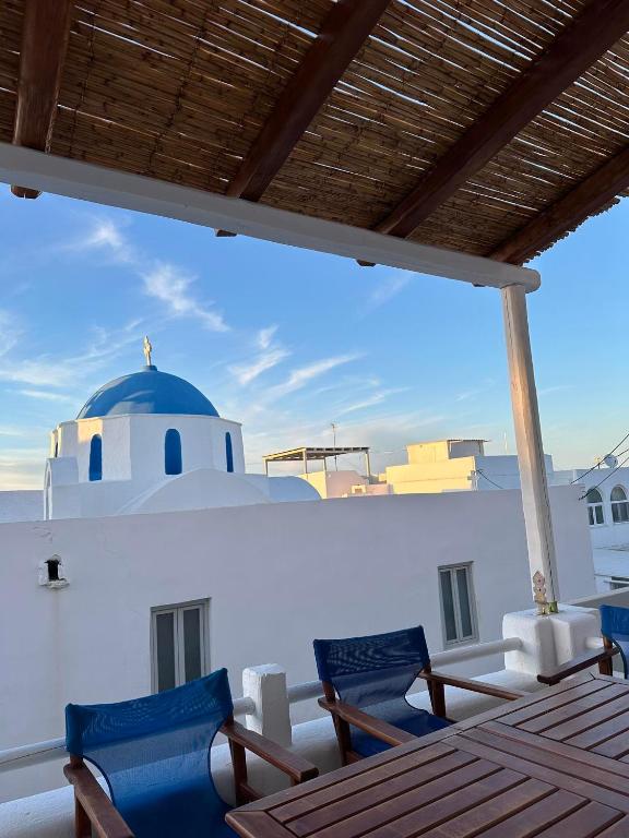 a balcony with chairs and a blue dome on a building at Harry’s studio in Naousa